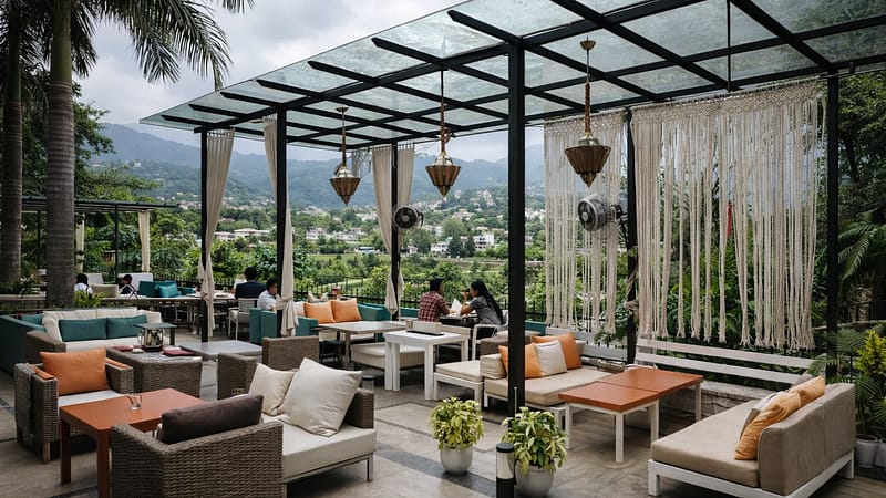 Outdoor seating area in Dehradun café surrounded by greenery